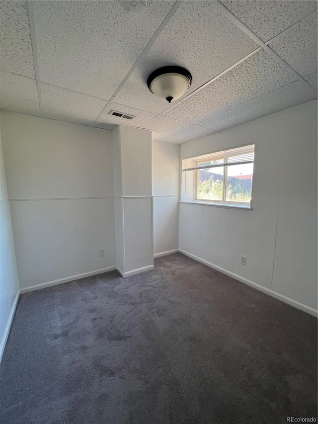 carpeted empty room with a drop ceiling