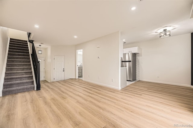 3200 S Federal Blvd Unit 5, Denver, CO 80236 - unfurnished living room with stairs, light wood finished floors, and recessed lighting