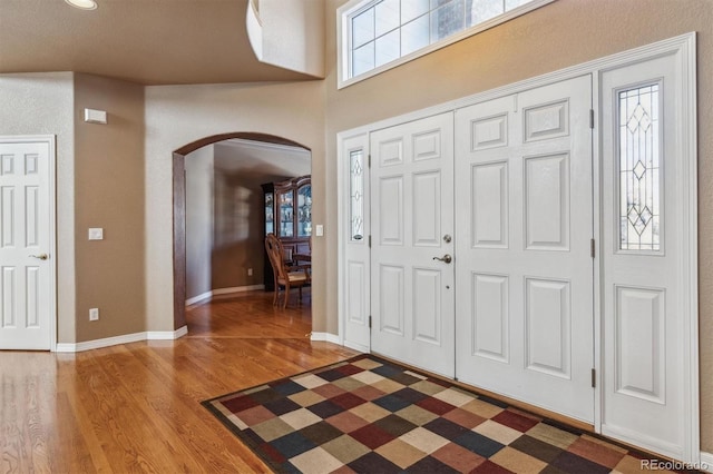 foyer entrance with hardwood / wood-style flooring and a high ceiling