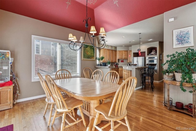 dining area featuring light wood-type flooring and a chandelier