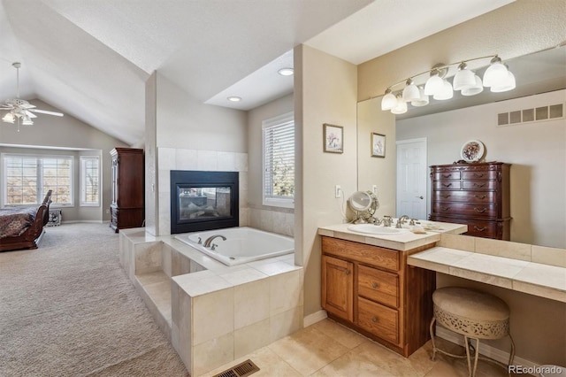 10834 Bobcat Ter, Lone Tree, CO 80124 - ensuite bathroom with a bath, vanity, lofted ceiling, a tile fireplace, and ceiling fan
