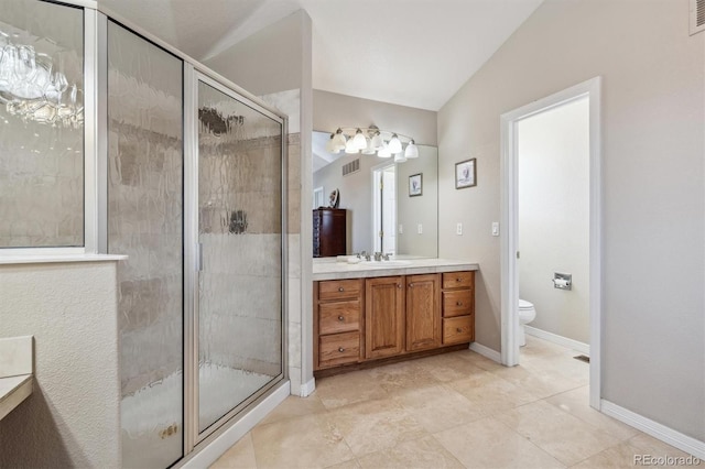 bathroom with tile patterned floors, vanity, vaulted ceiling, a shower with door, and toilet