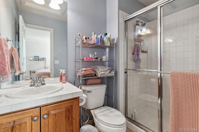 bathroom featuring an enclosed shower, vanity, toilet, and ornamental molding