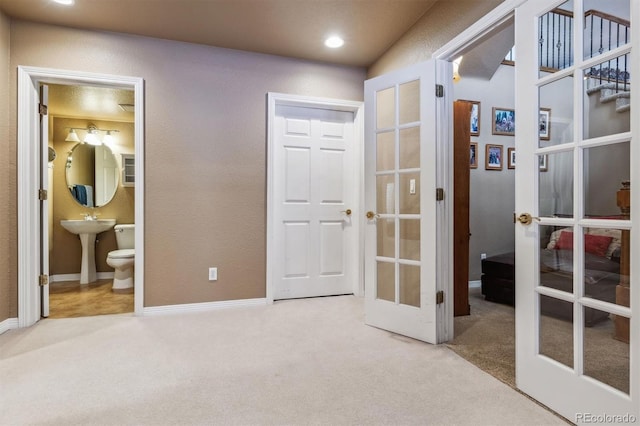 carpeted bedroom featuring ensuite bath and french doors