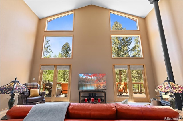 living area with a wood stove and high vaulted ceiling