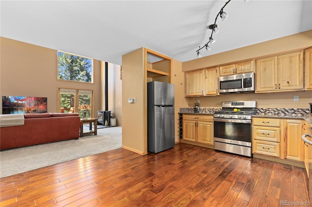 kitchen featuring stainless steel appliances, light brown cabinets, and dark wood finished floors