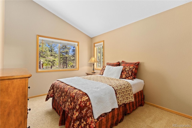 carpeted bedroom with baseboards and vaulted ceiling