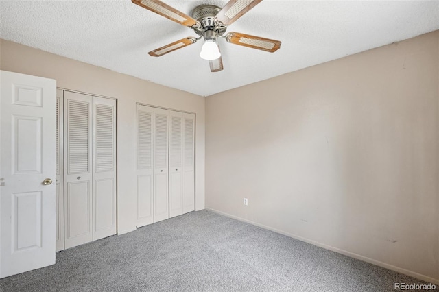 6545 Brook Forest Dr, Colorado Springs, CO 80911 - unfurnished bedroom with carpet flooring, two closets, ceiling fan, and a textured ceiling