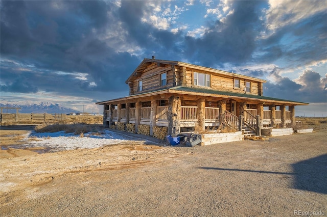 log cabin featuring covered porch