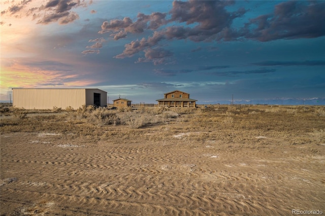 yard at dusk featuring an outdoor structure