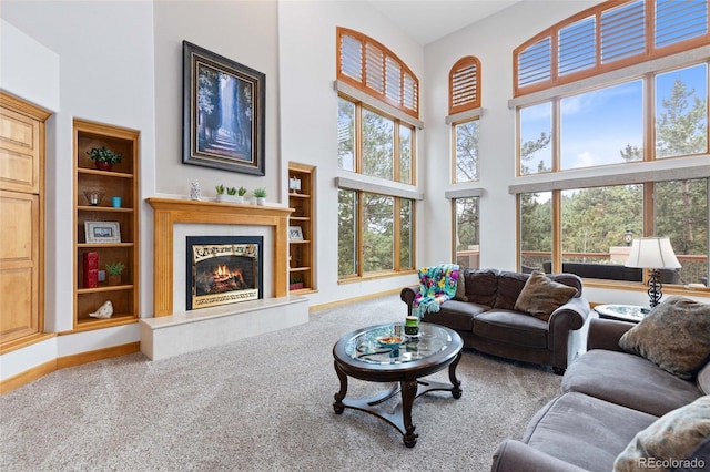 living room with carpet flooring, built in features, and a high ceiling