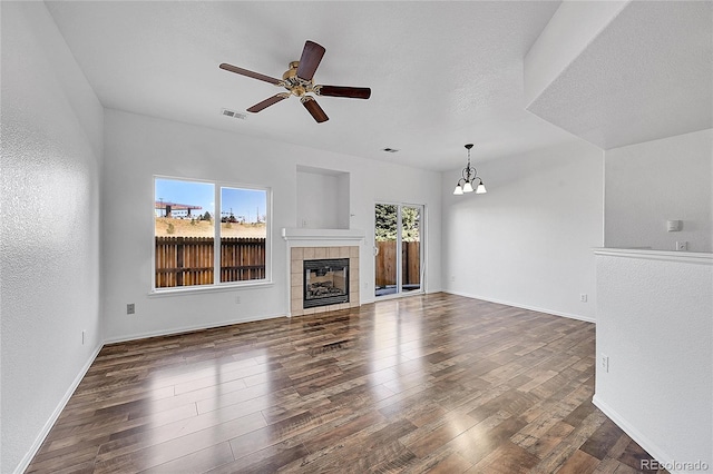 unfurnished living room with dark wood finished floors, plenty of natural light, a fireplace, and visible vents