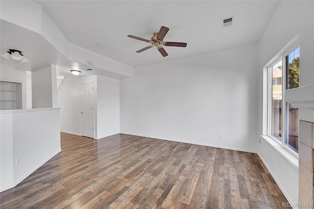 empty room with visible vents, baseboards, ceiling fan, and wood finished floors