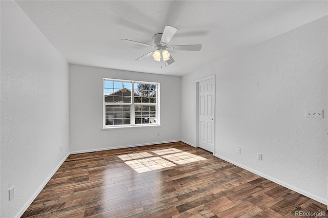 empty room featuring a ceiling fan, wood finished floors, baseboards, a textured ceiling, and a textured wall