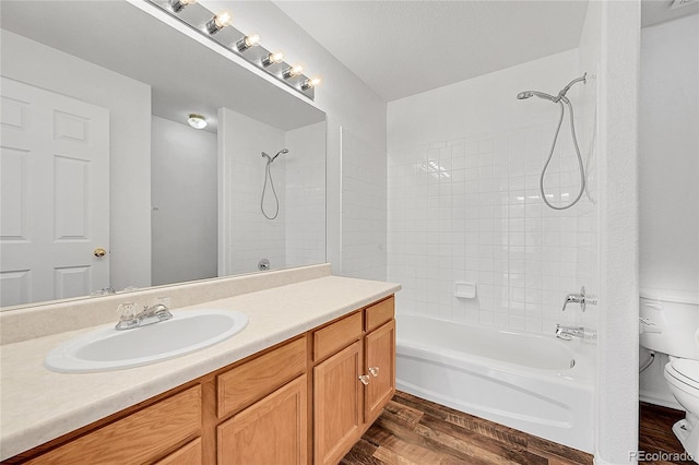 bathroom featuring vanity, toilet, shower / tub combination, and wood finished floors