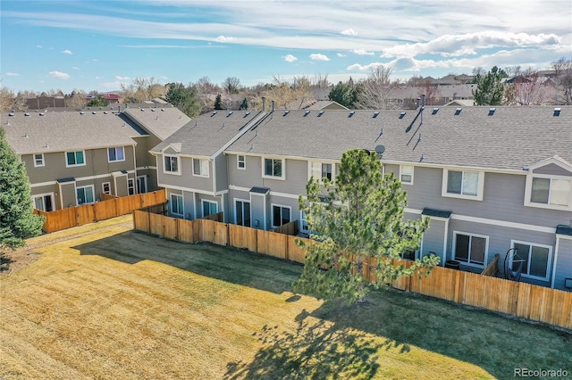 exterior space with a yard, fence, and a residential view