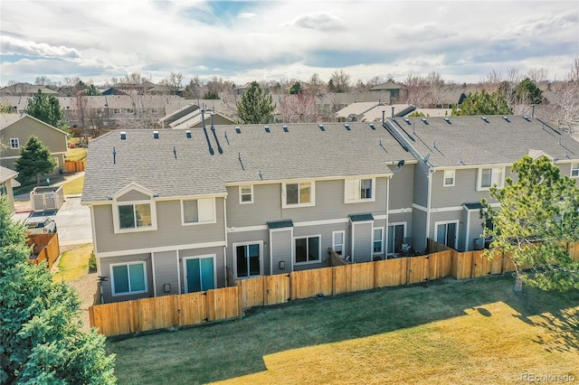 rear view of property with a residential view, a lawn, and fence