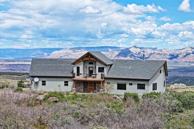 53315 Bull Basin Rd, Mesa, CO 81643 - back of property with a mountain view, a shingled roof, stone siding, and a balcony