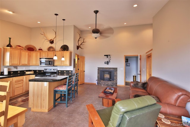 53315 Bull Basin Rd, Mesa, CO 81643 - living area featuring a towering ceiling, a ceiling fan, recessed lighting, baseboards, and a stone fireplace