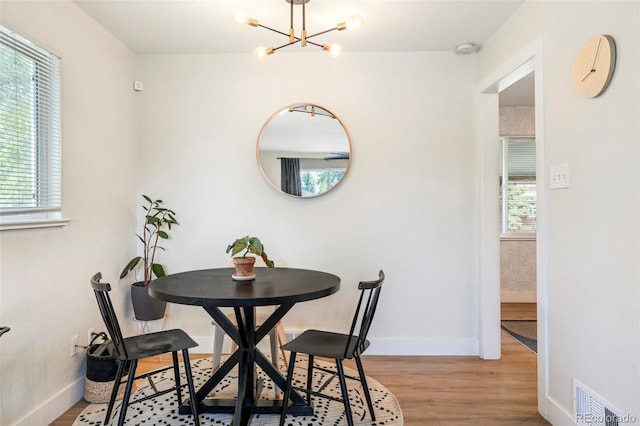1749 Havana St, Aurora, CO 80010 - dining area featuring a chandelier, wood finished floors, and baseboards