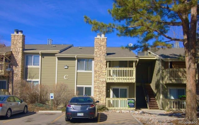 view of building exterior featuring stairs and uncovered parking