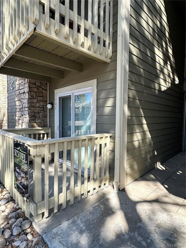 doorway to property featuring a wooden deck and stone siding