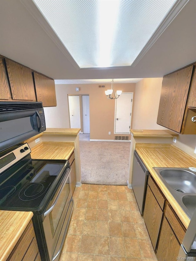 kitchen featuring visible vents, light carpet, appliances with stainless steel finishes, light countertops, and a notable chandelier