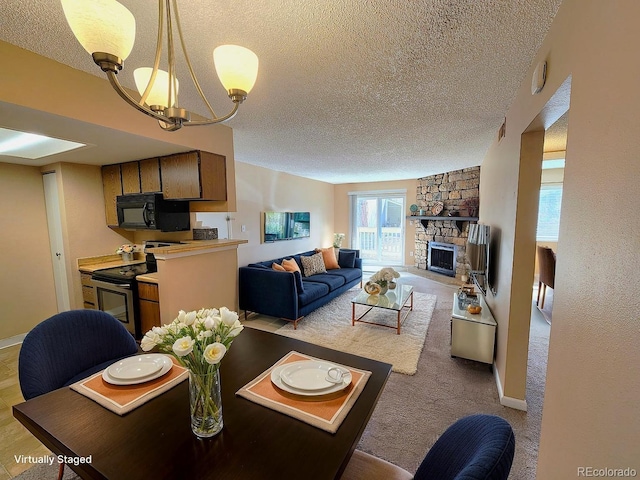 dining area featuring visible vents, baseboards, a notable chandelier, a stone fireplace, and a textured ceiling