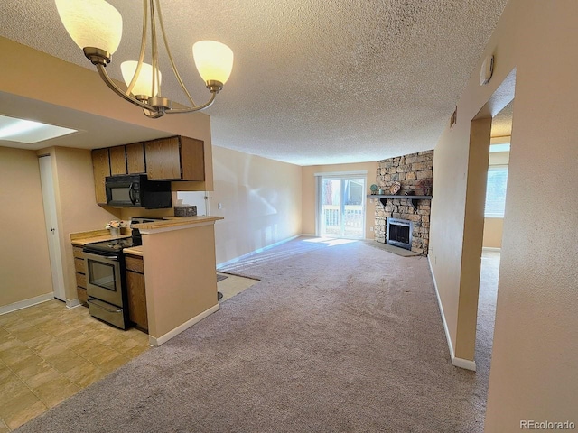 kitchen featuring a stone fireplace, an inviting chandelier, black microwave, stainless steel electric range oven, and a textured ceiling