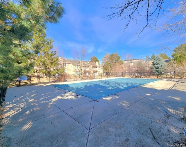 pool with a patio area and fence
