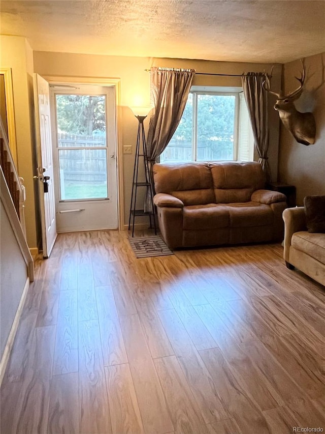 unfurnished living room with a textured ceiling and wood-type flooring