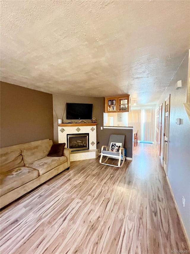 unfurnished living room with hardwood / wood-style flooring and a textured ceiling