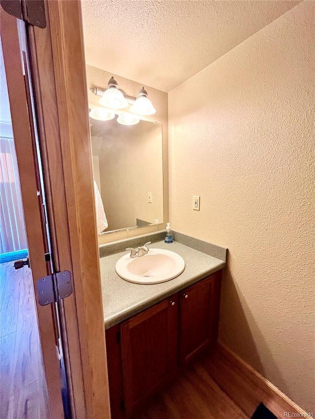 bathroom featuring vanity, a textured ceiling, and hardwood / wood-style floors