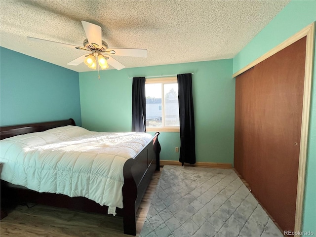 bedroom featuring ceiling fan, wood-type flooring, and a textured ceiling