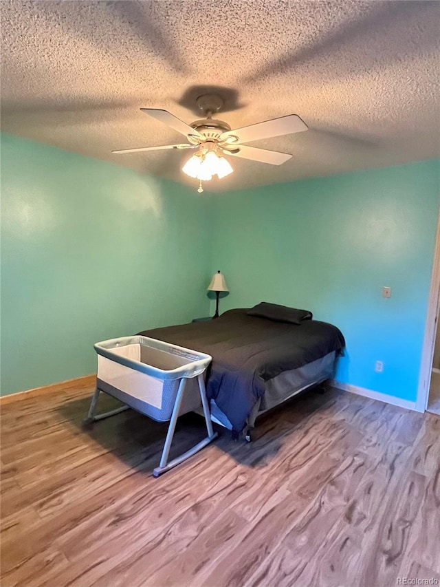 bedroom featuring a textured ceiling, ceiling fan, and hardwood / wood-style floors