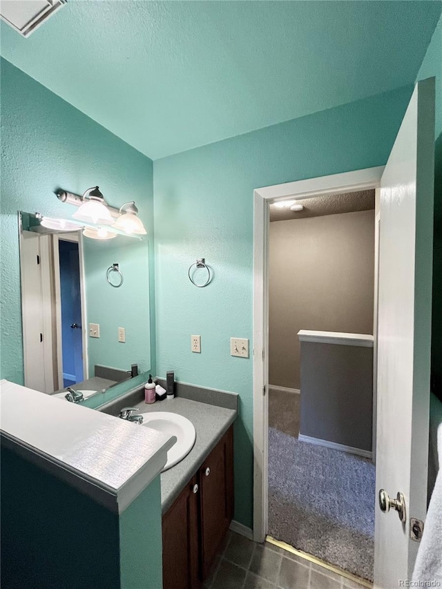 bathroom featuring a textured ceiling and vanity