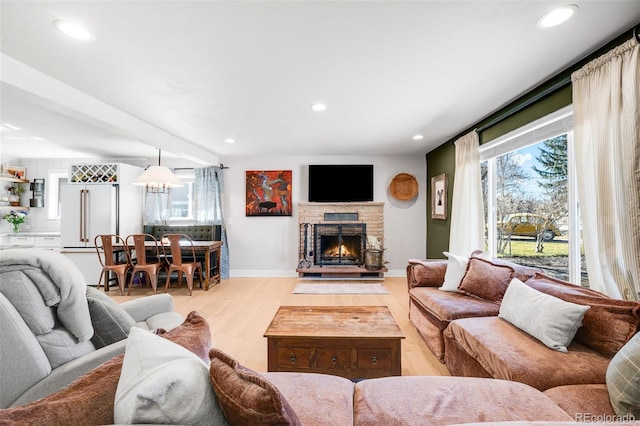 living room with light wood-type flooring, plenty of natural light, a fireplace, and recessed lighting