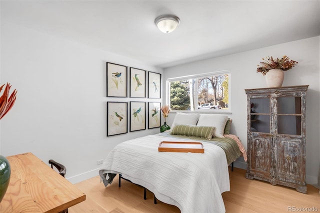 bedroom with light wood-style flooring and baseboards