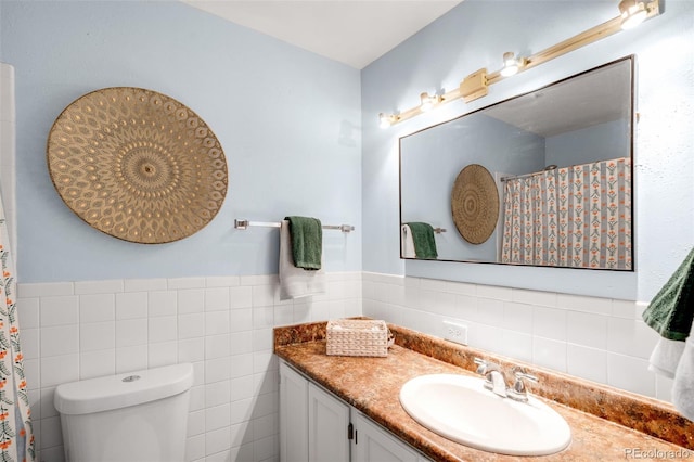 bathroom featuring a shower with shower curtain, toilet, a wainscoted wall, vanity, and tile walls