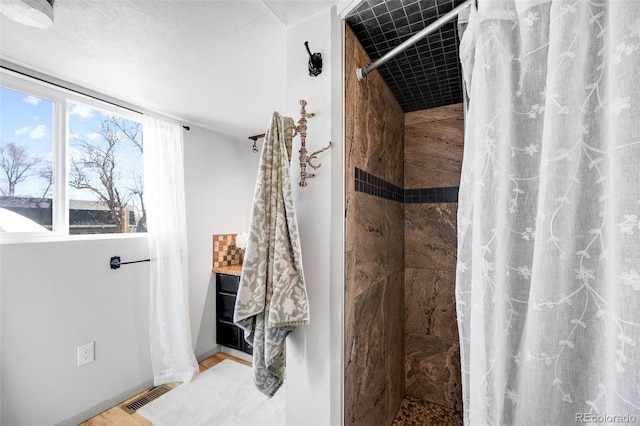 bathroom featuring visible vents and tiled shower