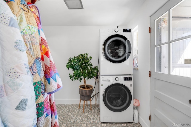 laundry room with laundry area, stacked washing maching and dryer, and baseboards