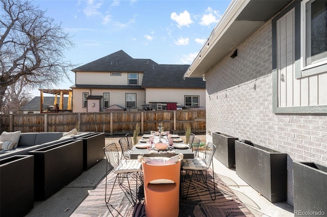 view of patio featuring outdoor dining area, fence, and an outdoor living space