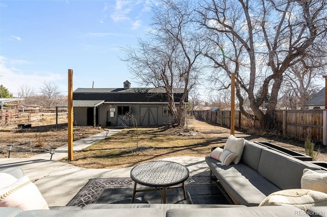 view of patio featuring an outbuilding, a fenced backyard, and an outdoor living space