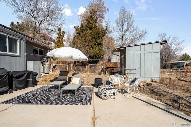 view of patio / terrace with fence and an outbuilding