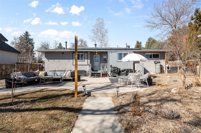 rear view of house with entry steps, a patio, fence, outdoor lounge area, and brick siding