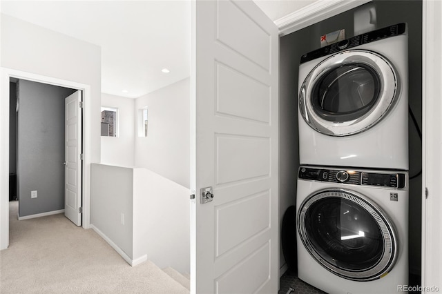 laundry area featuring stacked washer / dryer and light colored carpet