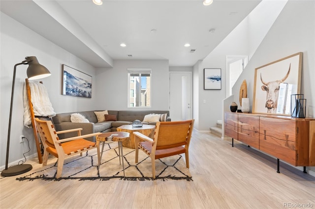 living room featuring baseboards, visible vents, stairway, wood finished floors, and recessed lighting