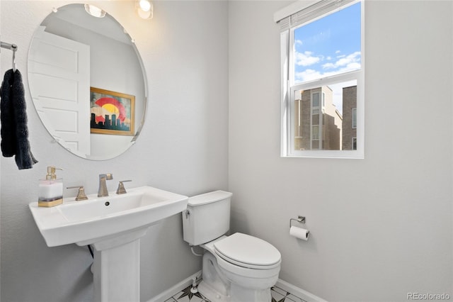 bathroom with baseboards, a sink, and toilet