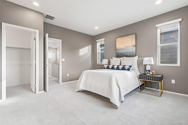 carpeted bedroom with baseboards, visible vents, a walk in closet, a closet, and recessed lighting