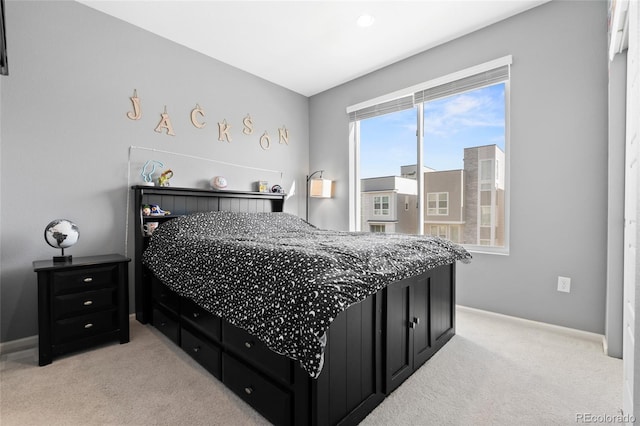 bedroom with light carpet and baseboards